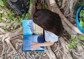 Niña fomentando el respeto por la naturaleza desde su infancia, leyendo al aire libre, explorando la naturaleza, beneficiando su desarrollo infantil a través de la observación de aves, cultivando el amor por la naturaleza