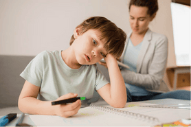 Niño distraído al realizar una actividad, uno de los comportamientos comunes del TDAH en la infancia y que tiene un impacto en el rendimiento escolar infantil, pero existen estrategias y dinámicas familiares para niños con TDAH